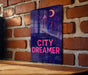 a sign on a brick wall that says city dreamer