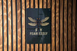 a sign on a wooden wall that says fly fearlessly