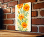 a painting of orange flowers on a brick wall