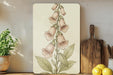a painting of a flower on a wall next to a cutting board
