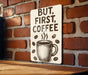 a sign on a brick wall that says, but first coffee