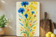 a painting of blue flowers on a yellow background