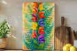 a painting of flowers on a wall next to a cutting board