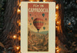 a sign that reads fly in cappadocia with hot air balloons