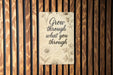 a sign on a wooden wall that says grow through what you through