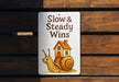 a sign that says slow and steady wins with a snail on it