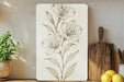 a picture of a flower on a wall next to a cutting board
