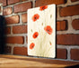 a picture of some red flowers on a brick wall