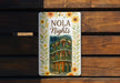 a sign on a wooden bench that says nola nights