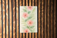 a painting of pink flowers on a wooden wall