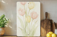 a painting of tulips on a wall next to a cutting board