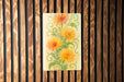 a painting of yellow flowers on a wooden wall