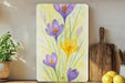 a painting of purple and yellow flowers on a shelf