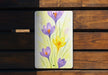 a painting of purple and yellow flowers on a wooden bench