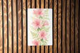 a painting of pink flowers on a wooden wall