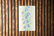 a painting of blue flowers on a wooden wall
