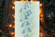 a painting of bluebells is hanging on a tree