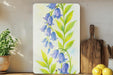 a painting of blue flowers on a white board