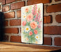 a painting of flowers is hanging on a brick wall