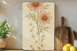 a painting of flowers on a wall next to a cutting board