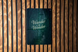 a wooden wall with a sign that says wander in wonder
