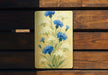 a painting of blue and white flowers on a wooden bench