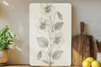 a picture of a flower on a wall next to a cutting board