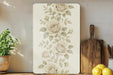 a painting of flowers on a wall next to a cutting board