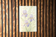 a painting of purple flowers on a wooden wall