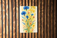 a painting of blue flowers on a wooden wall