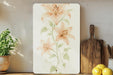 a painting of flowers on a wall next to a cutting board