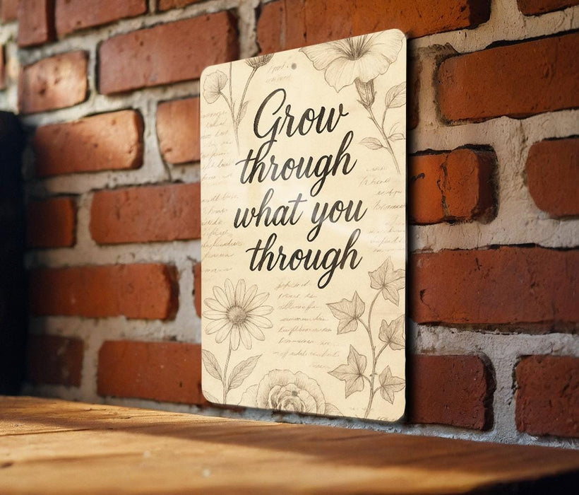 a sign on a brick wall that says grow through what you through