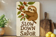 a wooden sign that says slow down and savor