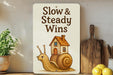 a sign that says slow and steady wins on a shelf