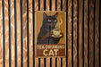 a sign on a wooden wall that says tea drinking cat