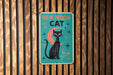 a blue sign with a black cat sitting on top of it