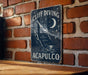 a sign on a brick wall that says cliff diving acapuloco