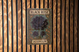 a black rose sign on a wooden wall