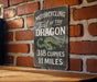a sign on a brick wall that says motorcycling fall of the dragon