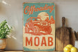 a sign that says offroading moab on a shelf