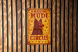 a sign on a wooden wall that says amazing mudi circus