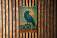 a blue bird sitting on top of a wooden sign