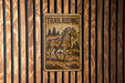 a trail riding sign mounted to a wooden wall