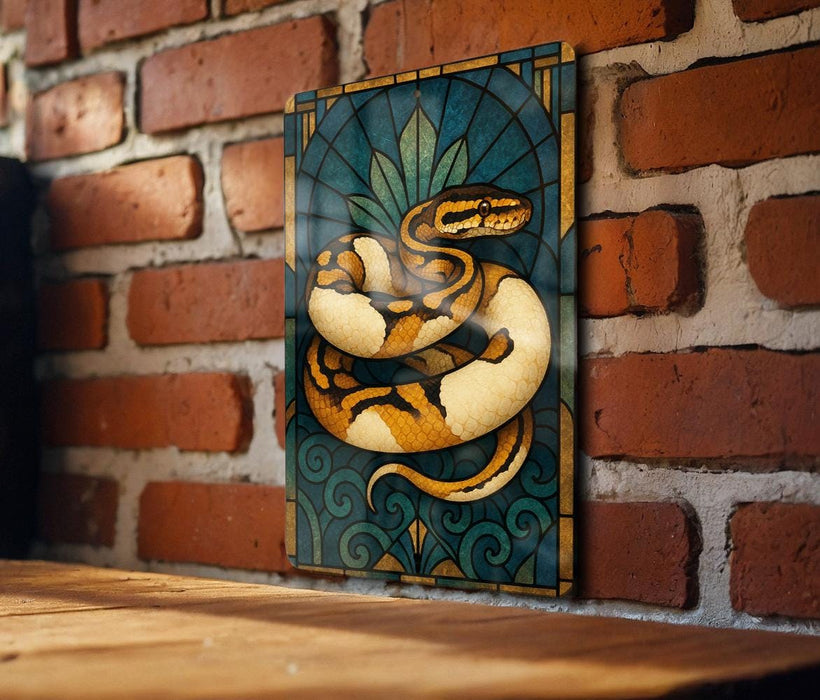 A framed stained glass artwork depicting a colorful snake is displayed on a brick wall.