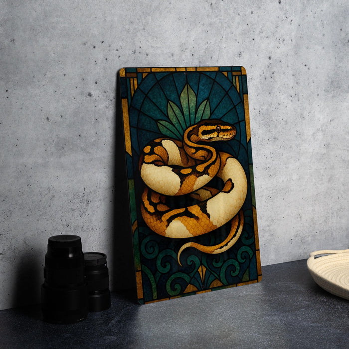 a framed painting of a snake on a blue and green background, placed on a table next to some black camera lenses.