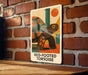 A metal sign with a colorful illustration of a tortoise is mounted on a brick wall.