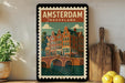 A framed poster of Amsterdam, Netherlands, featuring a colorful illustration of the city's iconic canal-side buildings and bridges.