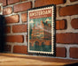 A vintage-style postage stamp depicting a brick wall with a bridge and buildings, mounted on a brick wall.