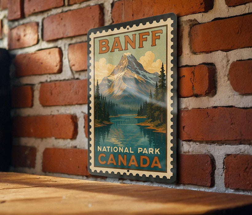 A vintage-style metal sign for Banff National Park, featuring a mountain landscape and a lake, is displayed on a brick wall.