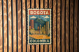 A vintage-style poster of Bogota, Colombia, featuring a cityscape with buildings, a church, and a mountain.